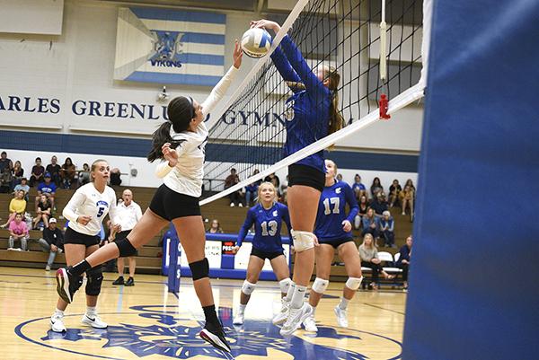 West Iron junior Kali Harty attempts to tip the ball past Calumet blocker Helen Beiring in the Wykons’ first dual match of the season against the Copper Kings on Sept. 1 at Charles Greenlund Gymnasium. WIC’s Adi Franzene looks on.