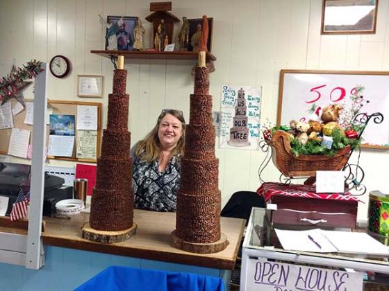 St, Vincent de Paul Crystall Falls manager Elaine Griffiths stands between two towers composed of pennies.  According to Griffiths, 9 weeks were required to complete the first of the two towers.  any penny tree over in its entirety. (Photo/R.R. Johnson)