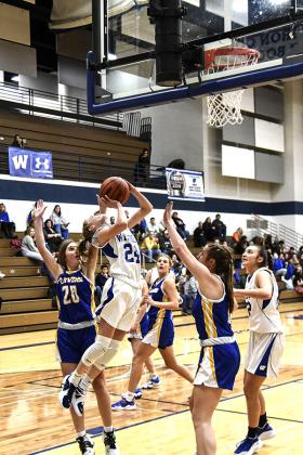 Wykons standout sophomore #24 Danica Shamion goes up for a shot while surrounded by Kingsford Flivvers defenders.  Flivvers junior #20 Erika Malone appears to barely get a hand on the ball. (Photo/Kevin Zini)