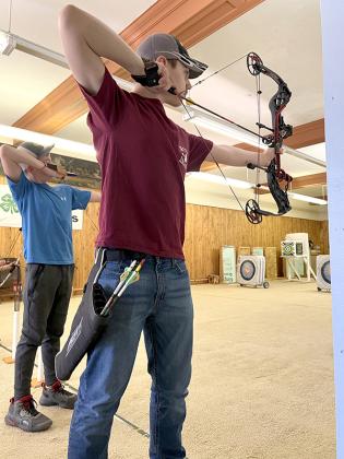 Jackson Roberts (pictured left) and Brennon Gursky draw back their bows to shoot at the indoor archery and air rifle range at Artemis Archery in Crystal Falls. Roberts is a first-time shooter while Gursky has been shooting in the 4-H Sharp Shooters club for the last five years.