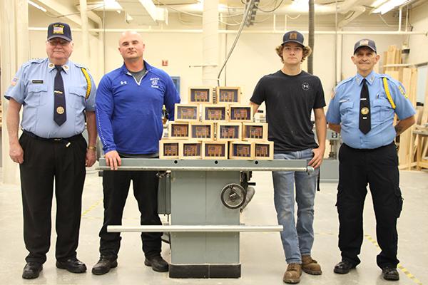West Iron County High School woodshop students, Johnothan Swenski, Caleb Strom and Jackson Strom, worked diligently this year making 32 shadow boxes during class. These shadow boxes were presented to the West Side Veterans Honor Guard on May 27. The West Side Veterans present these boxes to families of service members at their funerals. In each box are three empty casings from the three-volley salute in honor of the fallen Veterans service. Pictured are, from left, Dick Weatherholt, Zack Goodman, Johnothan 