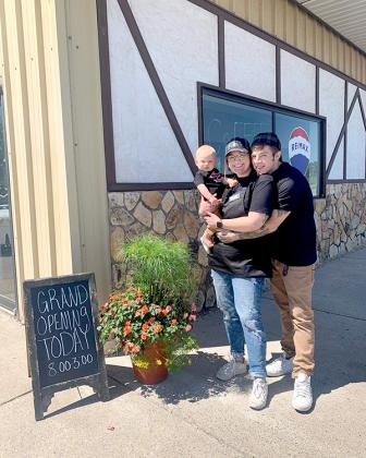 Kimberly Spigarelli poses with her nine-month-old son, Welden (left) and boyfriend, Derek Carpenter in front of her new business, Buddha Bean Coffee Company. The coffee shop had its grand opening on June 18. (submitted photo)