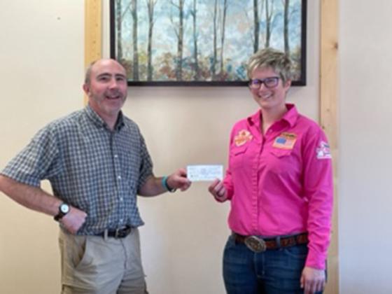 Ashley Burke, U.P. Rodeo Co-Chair, presents Kevin Isaacson of the Iron County Cancer Unit, a check for $2,220 from the Tough Enough to Wear Pink promotion at the U.P. Championship Rodeo.  They also donated $2,385 to the Caring House in Iron Mountain from the Man Up Crusade rodeo promotion. (submitted photo)