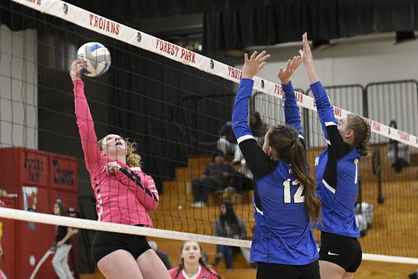 Forest Park Junior, Leah Feldhausen (15) makes a play at the net against Lady Wykons opponents, Haiden Gill (12) and Danica Shamion (7). 