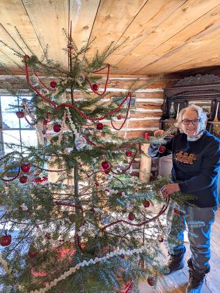 Pictured is Mansfield Memories Committee president, Pat Dishaw putting the finishing touches on the balsam Christmas tree. The Mansfield Pioneer Church will host their annual Christmas service on Tuesday, Dec. 13 at 6:30 p.m. (submitted photo)