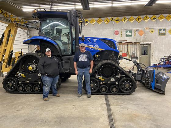Nick Wiegand, Iron Range Trail Club president (left) stands with Ernie Reimann, club member in front of the club’s New Holland tractor. The club has a team of groomers who maintain the trails to keep them safe for snowmobile riders. (0photo by Kate Collins)